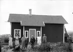 Gruppfoto på gården framför huset.