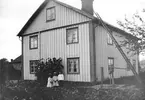 Slaktare F E Sundwalls hus i Solberga, Torsåker, omkring 1910. Barnen från vänster Anny Aurina, Jenny Maria och Frans Harry. Huset till vänster var postkontor (ett av landets äldsta) fram till 1875 då det flyttades till Torsåkers Järnvägsstation. Gårdspumpen är typisk för Torsåker. Tillverkad av Lingvalls Mekaniska Verkstad i Prästhyttan.