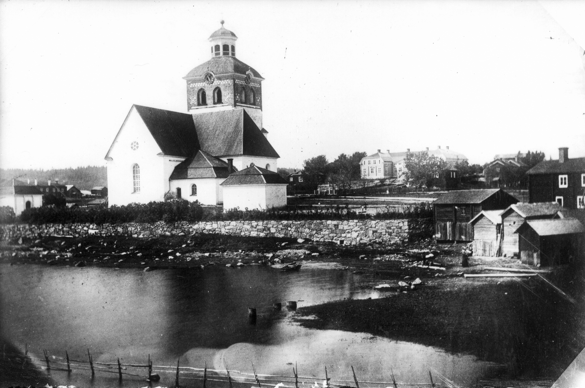 Bollnäs kyrka före 1877-1878. Längst bak till vänster gården Kämpens, nuvarande Bollnäs hembygdsgård. Till höger "fattigstugan". Bröderna Nilsson har reprofotograferat en äldre bild.