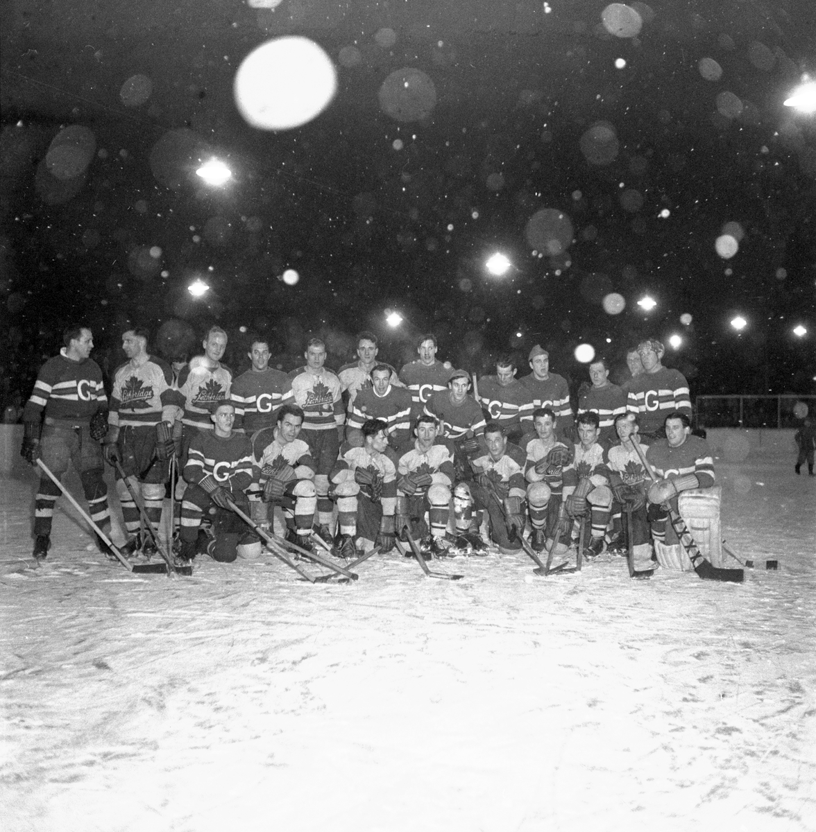 Ishockeymatch GGIK - Canada i februari 1951. Tröjor med G på. Stående från vänster: Erik "Jätten" Eriksson, Arne Backman, Sven Wickman, Curt "Gringo" Cederwall, Karl-Erik Djusberg, Herbert Pettersson, Bertil "Bomben" Carlbaum eller Sune "Bajan" Bohlin, Hans "Stöveln" Öberg och ev. Fernström. Nedre raden längst till vänster: Gunnar "Nilas" Brundin och Nils "Katten" Bergström.