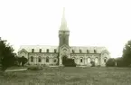 Borgholms kyrka på ett foto från 1906. En buske skymmer en del av kyrkporten.