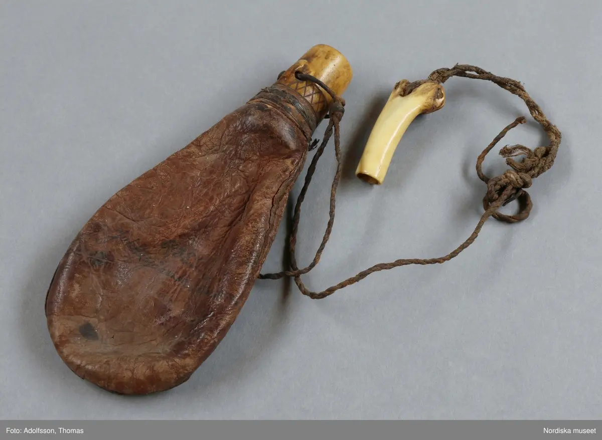 Huvudliggaren:
"Skjutdon fr. Jukkasjärvi sn, Torne lappmark. Från Piilijärvi. Kulpung af skinn och krutmått af ben. Förf. af Olof Johan Nilsson. Ink. af jägmästaren Hugo Samzelius. 1891. Bil. Samzelius 85."