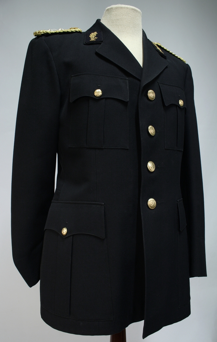 Uniform for politinspektør etter 1963-reglement med merking etter 1977-reglement. Helårsuniform M/1963 med skjorte, langbukse, belte, helårskappe og jakke. Skyggelue med gullbrodert bånd, loslue og båtlue M/1967. Kappen og jakken har skulderklaffer av flettede gullsnorer med to sølvstjerner og festeknapp i gullbroderi. Skjorten har en enklere skulderklaff med to gule render og to sølvstjerner. Det følger med et ekstra enkelt lærbelte og et ekstra sett skulderklaffer til skjorte. Plaggene har gullfargede løveknapper.