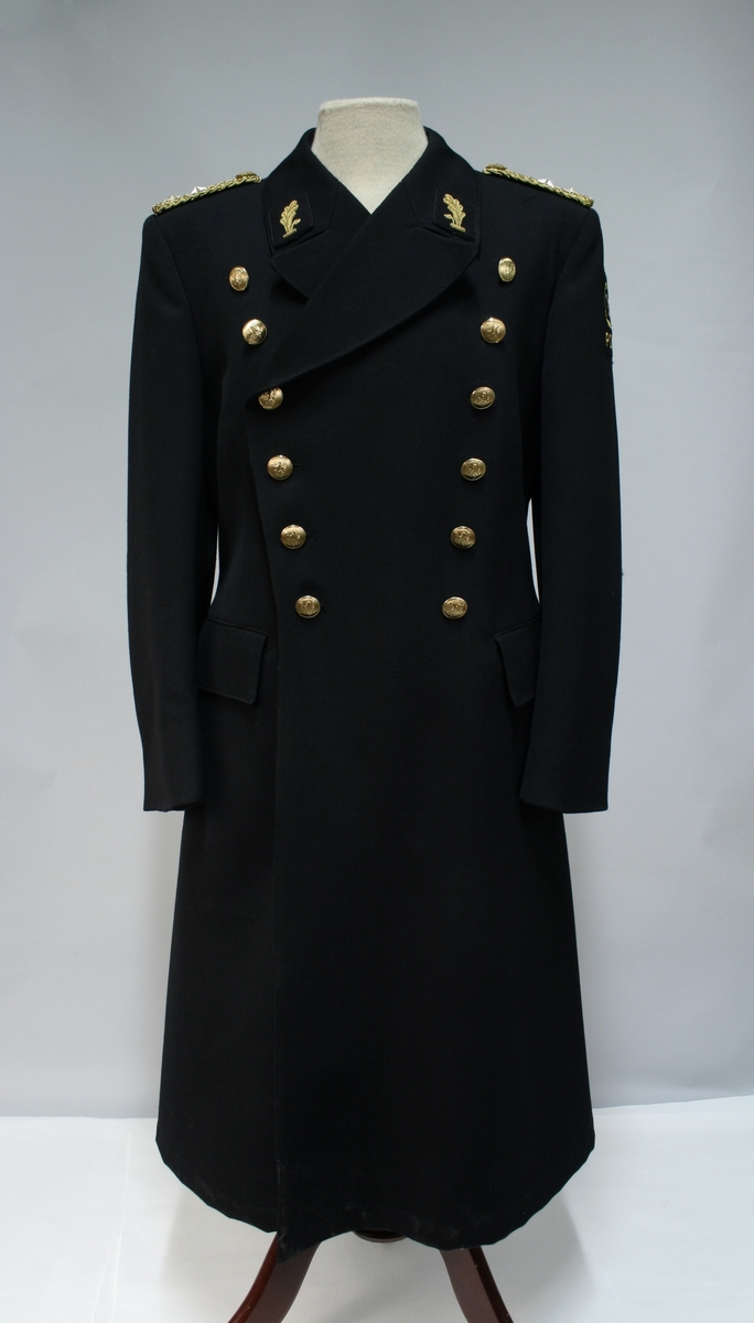 Uniform for politinspektør etter 1963-reglement med merking etter 1977-reglement. Helårsuniform M/1963 med skjorte, langbukse, belte, helårskappe og jakke. Skyggelue med gullbrodert bånd, loslue og båtlue M/1967. Kappen og jakken har skulderklaffer av flettede gullsnorer med to sølvstjerner og festeknapp i gullbroderi. Skjorten har en enklere skulderklaff med to gule render og to sølvstjerner. Det følger med et ekstra enkelt lærbelte og et ekstra sett skulderklaffer til skjorte. Plaggene har gullfargede løveknapper.