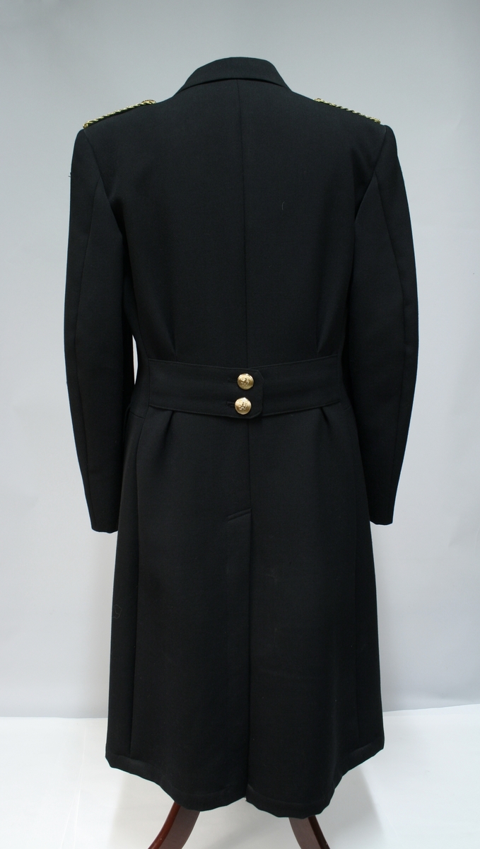 Uniform for politinspektør etter 1963-reglement med merking etter 1977-reglement. Helårsuniform M/1963 med skjorte, langbukse, belte, helårskappe og jakke. Skyggelue med gullbrodert bånd, loslue og båtlue M/1967. Kappen og jakken har skulderklaffer av flettede gullsnorer med to sølvstjerner og festeknapp i gullbroderi. Skjorten har en enklere skulderklaff med to gule render og to sølvstjerner. Det følger med et ekstra enkelt lærbelte og et ekstra sett skulderklaffer til skjorte. Plaggene har gullfargede løveknapper.