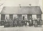 Hälsobrunnens första skola, byggd 1875, flyttad till Slättingebygd 1899. Bilden troligen tagen 1892. Lärarinnans namn är Dagmar Joelsson.