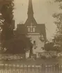 Dalhems gamla kyrka. 1874  före rivningen. Sydsidan med vapenhuset. Mellankyrkans gavel med blinderingar. Till vänster Fagradalskyrkan som var en del av kyrkan.Till höger koret. I bakgrunden till höger klockstapeln.