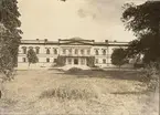 Gränsö slott,  gårdsfasaden. Byggt av timmer och klätt med  tjock puts. Byggt 1848 av byggmästare J. Jonsson, från Västervik 
Den äldre byggnad som fanns ingick i den nya. - Huset vitt, ornament grå.
