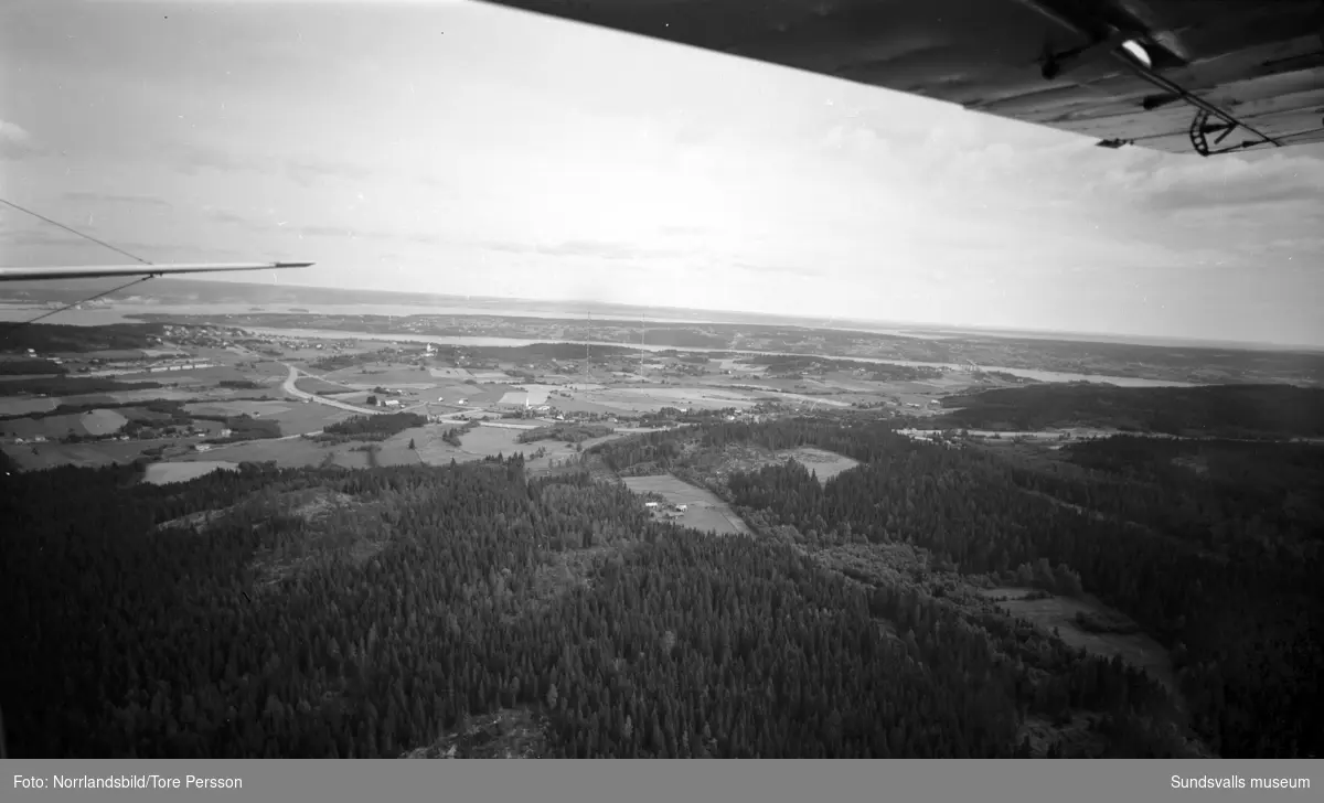 Flygfoto över Birsta och Ljustadalen tagen mot nordost. Mitt i bild syns de numera rivna radiomasterna, till vänster Sköns kyrka, till höger den nybyggda Alnöbron.