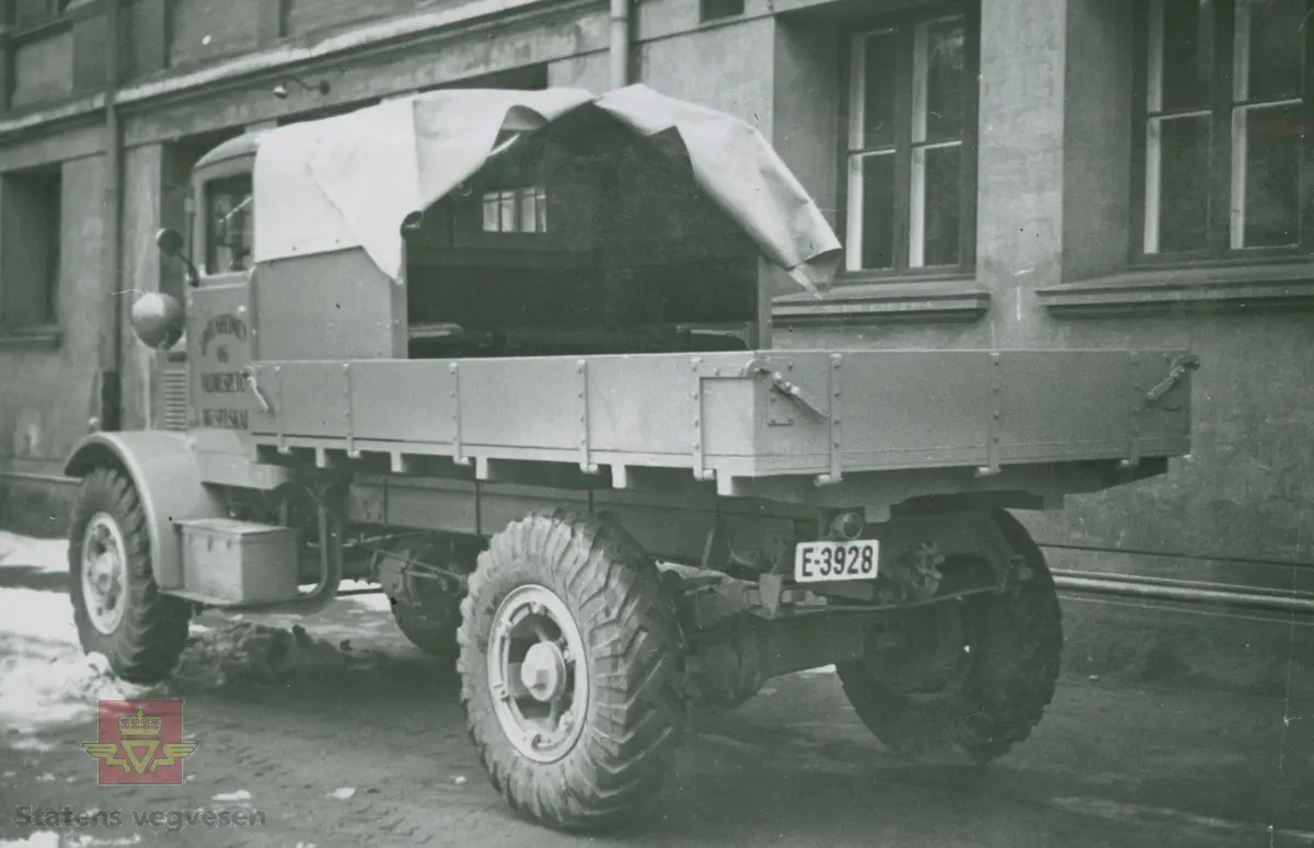 Tekst på bildet "Filefjell-Gubben". FWD lastebil modell SU fra A/S Jotunheimen og Valdresruten Bilselskap (JVB) med kjennetegn E-3928. Bilen ble levert til Jotunheimen, Valdresruten i 1936, og holdt vegen over Filefjell åpen. Klikk på pilen til høyre for å se tilleggsbilder: Legg merke til benkene på lasteplanet med tak og presenning til ly for vær og vind for brøytemannskap.   
Etter en tøff vinter 1936-1937 mottok Colbjørnsen brev fra JVB, A/S Jotunheimen og Valdresruten Bilselskap  30.04.1937, hvor de sier seg meget fornøyd med bilen de kjøpte før jul i 1936. Jf. boka "Familiefirmaet-utenom allfarvei/2000 Årsboken."Colbjørnsen & Co A/S, av Bjørn Ausjen Johannessen. Bilde av "Filefjell-Gubben" i A/S Jotunheimen og Valdresruten Bilselskap  på en av veivesenets garasjer på Filefjell vises i tilleggbildene.  FWD lastebilen "Filefjell-Gubben" ble innkjøpt av JVB  i 1936. Den til da kraftigste i landet. Vegfolk kom da også fra fjern og nær for å bivåne brøytingen, og for å se og lære. 
 "A/S Jotunheimen og Valdresruten Bilselskap  ble etablert i 1919 og har vært selve livsnerven gjennom Valdresbygdene. "Filefjell-Gubben" ble satt inn i arbeidet med å holde Filefjellvegen oppe. Med felles innsats og arbeid fra Staten og selskapets side, lykkes det å holde Filefjellvegen farbar for vintertrafikk vinteren 1936-1937, den første fjellovergang i Norge som var åpen året rundt." Jf. Kilde: "JVB. Den spede begynnelse-A/S Jotunheimen og Valdresruten Bilselskap."  
Personene på bildet er ukjente. Bildene som vises er både fra Oslo og Filefjell. 
Bildene er registrert enkeltvis på nr: 
Bilde 2) NVM 00-F-33671
Bilde 3  NVM 00-F-33672
Bilde 4  NVM 00-F-33704
Bilde 5) NVM 00-F-33705
Bilde 6) NVM 00-F-33707
Bilde 7) NVM 00-F-33708
Bilde 8) NVM 00-F-33710
Bilde 9) NVM 00-F-33711
Bilde 10)NVM 00-F33659
Bilde 11)NVM 00-F33660