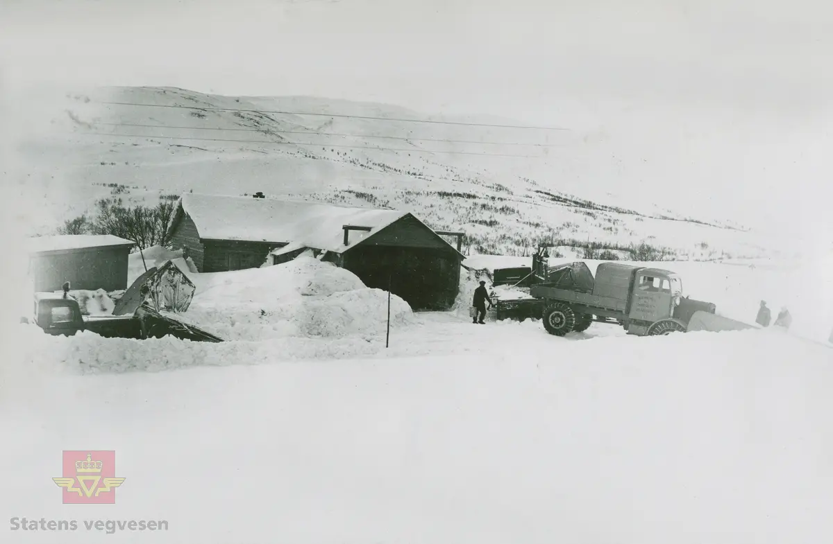 Tekst på bildet "Filefjell-Gubben". FWD lastebil modell SU fra A/S Jotunheimen og Valdresruten Bilselskap (JVB) med kjennetegn E-3928. Bilen ble levert til Jotunheimen, Valdresruten i 1936, og holdt vegen over Filefjell åpen. Klikk på pilen til høyre for å se tilleggsbilder: Legg merke til benkene på lasteplanet med tak og presenning til ly for vær og vind for brøytemannskap.   
Etter en tøff vinter 1936-1937 mottok Colbjørnsen brev fra JVB, A/S Jotunheimen og Valdresruten Bilselskap  30.04.1937, hvor de sier seg meget fornøyd med bilen de kjøpte før jul i 1936. Jf. boka "Familiefirmaet-utenom allfarvei/2000 Årsboken."Colbjørnsen & Co A/S, av Bjørn Ausjen Johannessen. Bilde av "Filefjell-Gubben" i A/S Jotunheimen og Valdresruten Bilselskap  på en av veivesenets garasjer på Filefjell vises i tilleggbildene.  FWD lastebilen "Filefjell-Gubben" ble innkjøpt av JVB  i 1936. Den til da kraftigste i landet. Vegfolk kom da også fra fjern og nær for å bivåne brøytingen, og for å se og lære. 
 "A/S Jotunheimen og Valdresruten Bilselskap  ble etablert i 1919 og har vært selve livsnerven gjennom Valdresbygdene. "Filefjell-Gubben" ble satt inn i arbeidet med å holde Filefjellvegen oppe. Med felles innsats og arbeid fra Staten og selskapets side, lykkes det å holde Filefjellvegen farbar for vintertrafikk vinteren 1936-1937, den første fjellovergang i Norge som var åpen året rundt." Jf. Kilde: "JVB. Den spede begynnelse-A/S Jotunheimen og Valdresruten Bilselskap."  
Personene på bildet er ukjente. Bildene som vises er både fra Oslo og Filefjell. 
Bildene er registrert enkeltvis på nr: 
Bilde 2) NVM 00-F-33671
Bilde 3  NVM 00-F-33672
Bilde 4  NVM 00-F-33704
Bilde 5) NVM 00-F-33705
Bilde 6) NVM 00-F-33707
Bilde 7) NVM 00-F-33708
Bilde 8) NVM 00-F-33710
Bilde 9) NVM 00-F-33711
Bilde 10)NVM 00-F33659
Bilde 11)NVM 00-F33660