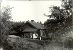 En familj dricke kaffe utanför sin stuga i Mossebo 1921.