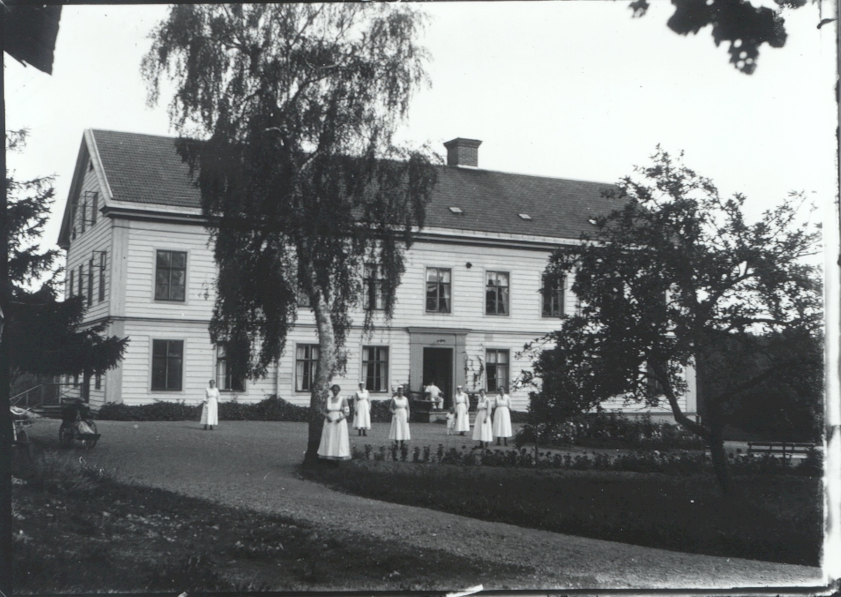 Personal utanför sjukhemmet i Hjorted, mitt emot skolhuset/församlingshemmet.