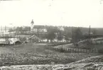 Vy från Hjorted med kyrkan i bakgrunden.