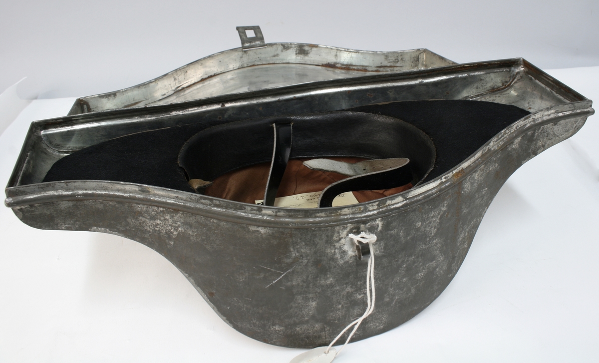 Hatten har nasjonalkokarde, krampe og besetning av possementsarbeid i gull.