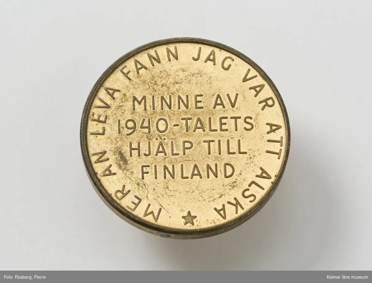 KLM 28668:247 Minnesmedalj, av metall, förgylld. Ytan sliten och nött. På ena sidan ett barn som sträcker sog efter en knoppande kvist samt signaturen WA. På andra sidan texten: Mer än leva fann jag var att älska, Minne av 1940-talets hjälp till Finland. Namnet, Ståls Penning, är hämtat ur Runebergs Fänrik Ståls säger, från dikten De två dragonerne, sista strofen. Devisen runt kanten på medaljens baksida är en inledningsstrof till dikten Molnets broder. Utformad av konstnären och skulptören Wäinö Aaltonen och präglades i hundratusentals exemplar. Såldes med anledning av Finlandshjälpen till förmån för alla de åtaganden som Hjälpkommittén hade för de finska krigsbarnen även efter andra världskrigets slut. Försäljningen pågick åren 1945-1947. Det blev en metod att samla in pengar, många barn var kvar på sjukhus och konvalescenthem, barnbespisning pågick i Finland. Den har säkert funnits i alla fosterhem och även hos många andra.