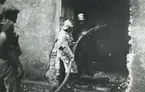Ångkvarnen i Kalmar. Branden juli månad 1935. Brandmän sprutar vatten när folk kollar på.