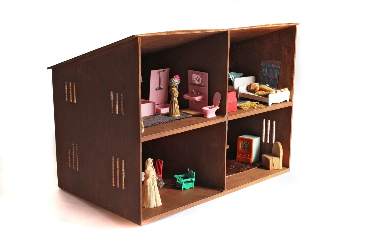 Gitt av Torill Lerdalen Hùser april 2015 til Anno Museum avdeling Kvinnemuseet. 
Dukkehuset er stort og i tre. Det har vinduer på sidene og åpen front. Består av diverse tilbehør og dukkesett. Totalt: 5 senger, bad, ei krybbe, 7 smådukker, sofa og stuemøblement, spisestue og kjøkken deler. Diverse små strikkede plagg og tepper. Hjemmesydde gardiner til vinduene. Det bærer preg av å inneholde møbler og leker fra fem tiår, og tre generasjoner som har lekt med dukkehuset. 

Hele historien som følger er skrevet ned av Torill selv bak på dukkehuset. Dukkehuset fikk Torill av sin far julen 1957 (Far: Halvard Lerdalen f.06/12.1916 Austvatn i Nord-Odal - 18.03.2010 Sand i Nord-Odal). Faren har laget dette selv. Torill ble kjempe glad når hun fikk dukkehuset. Hun hadde ønsket seg det lenge. Syntes det var så fint. Noen av møblene inne i dukkehuset har Torill snekret selv inne på sin fars verksted (Nærum Snekkerverksted, Sand i Nord-Odal). Dette er blant annet en spisestue med benk, sofa og skap. Dette snekret Torill når hun var 11 år i farens snekkerverksted. Det runde bordet med stoler i dukkehuset har Torill kjøpt for "hardt oppsparte penger". Det er kjøpt i Oslo, da Torill var hos tante Margit Otilie (Fars søster).
Torill skriver bak på dukkehuset: "Mye historie i disse gamle leker. Da var alt enkelt, og vi tok godt vare på det vi hadde. Penger var det lite av. 3/2-2013 signert Torill".
Fra undersiden av dukkehuset står det skrevet: Tonje Hùser (f.9/4.1971) også har lekt med huset. Likeså Tonjes døtre Amalie (22.04.21997) og Andrea (13.11.2003).