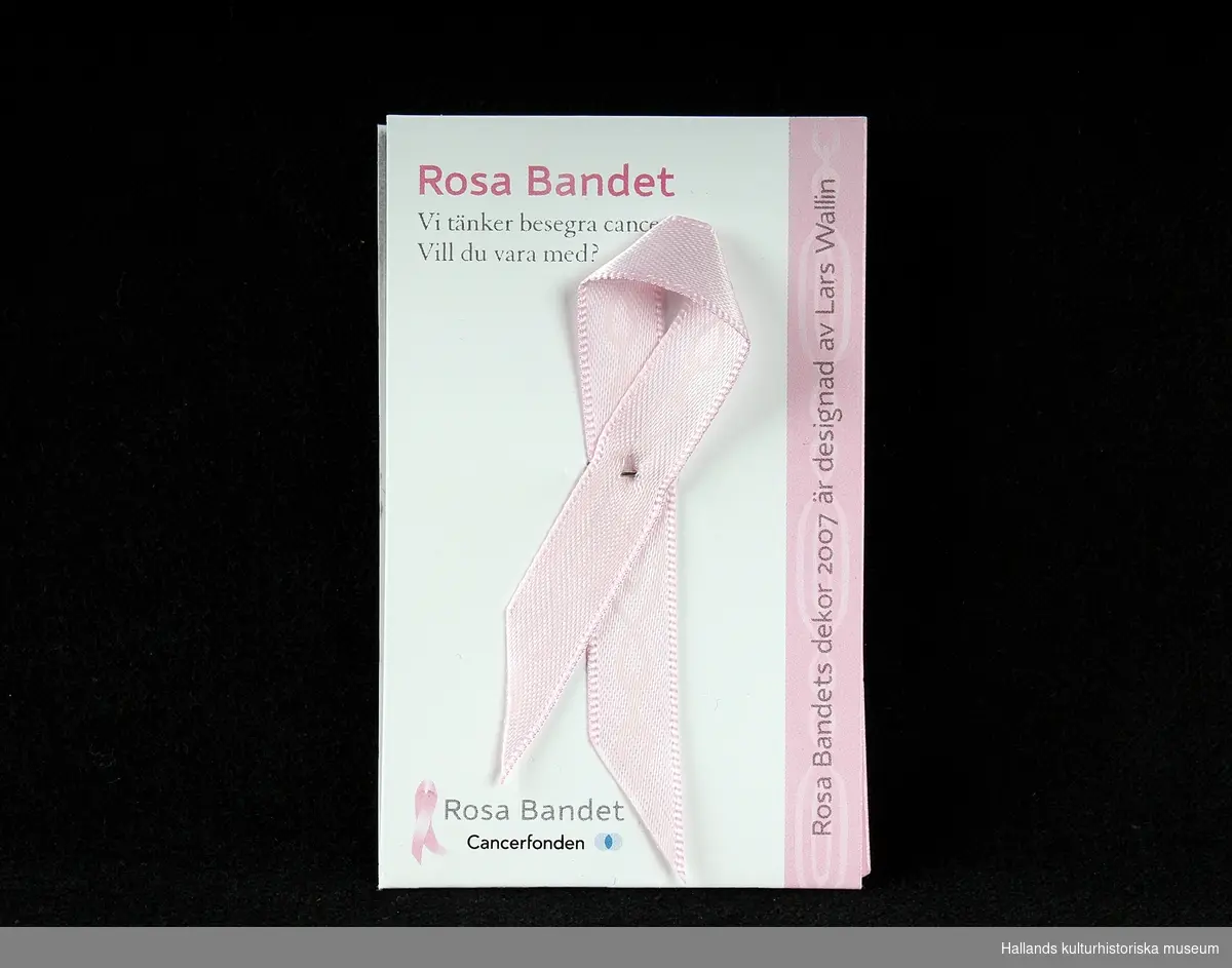 Fem stycken rockmärken, i form av "Rosa Bandet". Rosa "sidenband" vikt och sammansatt med liten säkerhetsnål. Bandet och en liten textbok ligger i en plastficka. Utvalda formgivare ger bandet varierat utseende varje år. 
a) 2006, Carin Rodebjer(trasmatta). b) 2007, Lars Wallin(kedja). c) 2008, Ingegerd Råman (text). d) 2009, Gert Wingårdh (blindskrift). e) 2011, Lena Ph, Per Holknekt (omfamning).