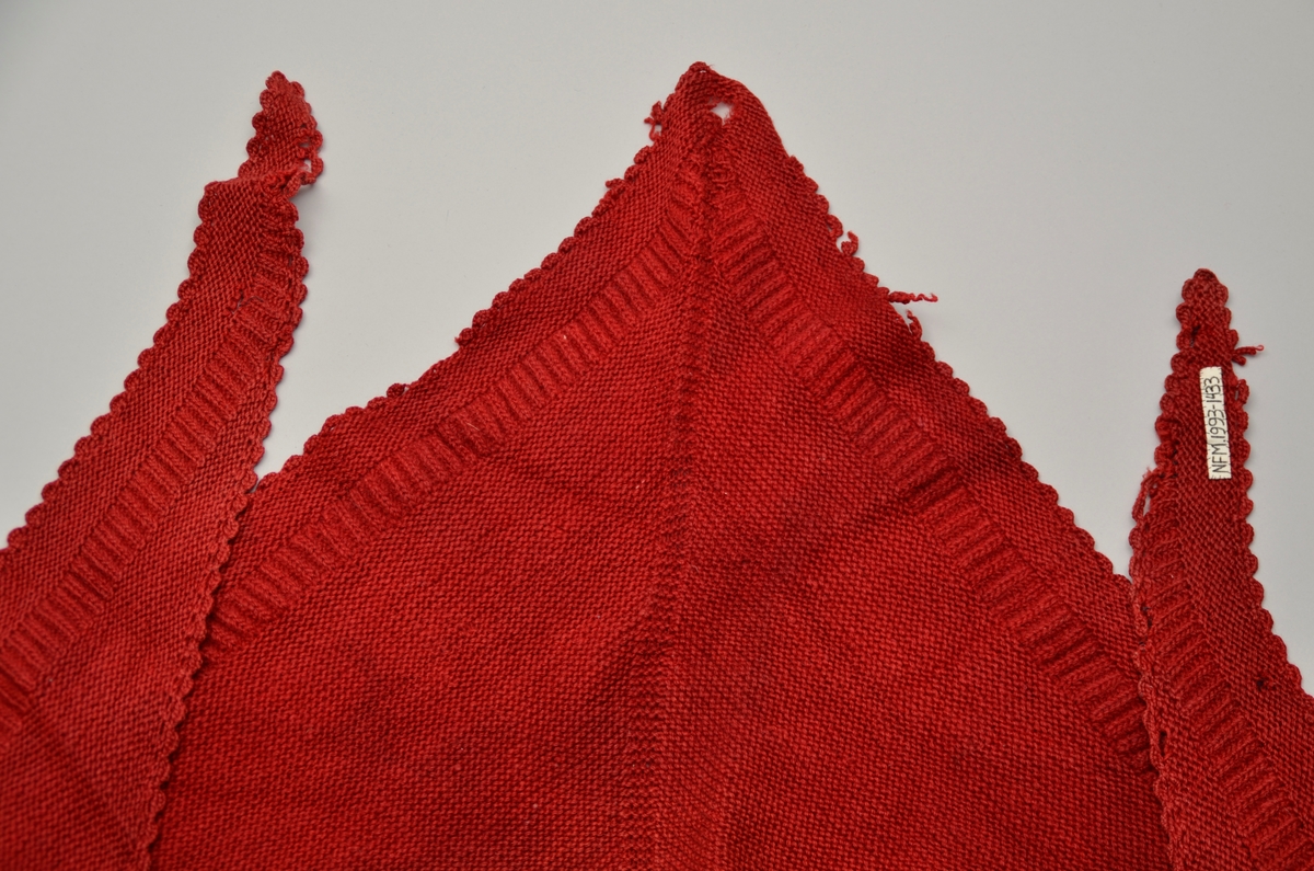 Raudt, strikka sjal med hekla kanting. V-form med kant midt på frå spiss og opp. Raudfargen er falma.