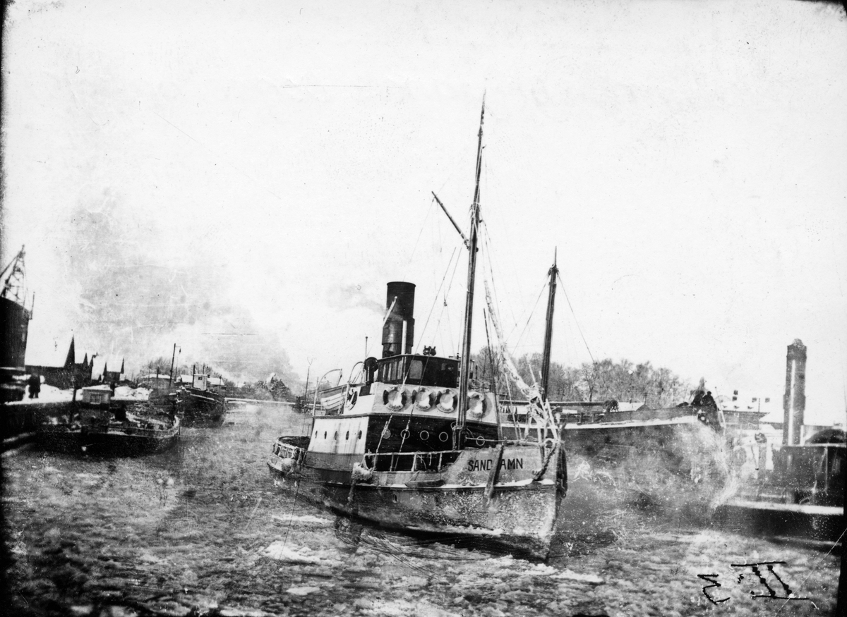 S/S Sandhamn, vinter 1910-tal. Vinterbild från övre hamnen då isbrytande bogserbåten Sandhamn rensar hamnen.