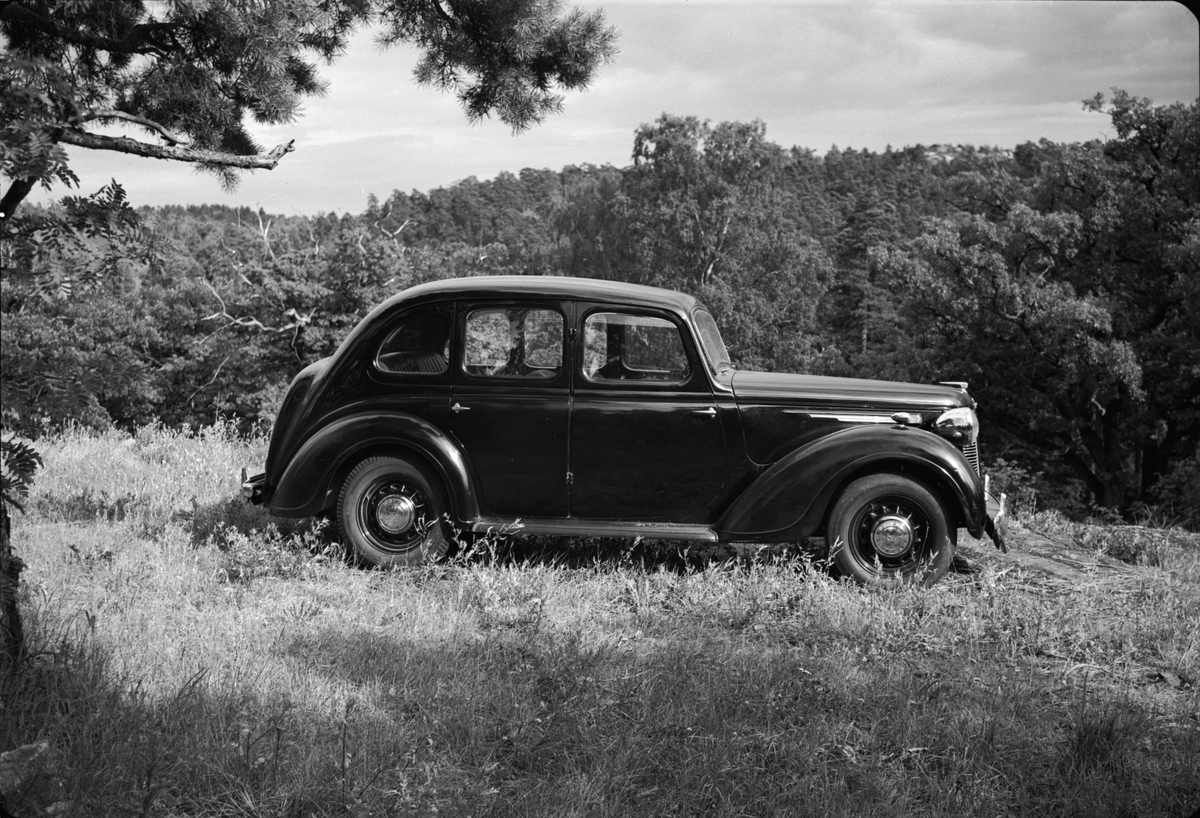 Bil av märket Hudson av årsmodell 1946-47, förlängd till 7-sitsig. Avbildad framför Drottningholms slott. På bilden syns även skulpturen Herkules kamp med draken av Adriæn de Vries, utförd i Prag 1590 - 1593.
