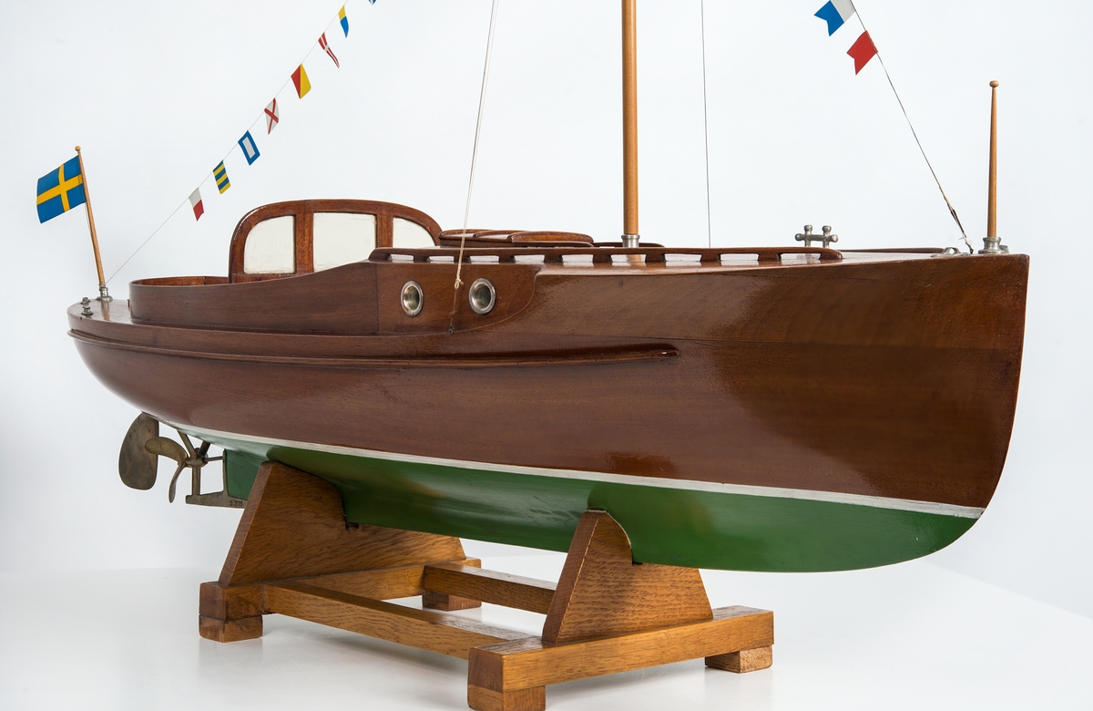 Helmodell av motorbåten WIKING X. Skrov av fernissad mahogny med grömålad botten, mässingsdetaljer. Skrå av ek.