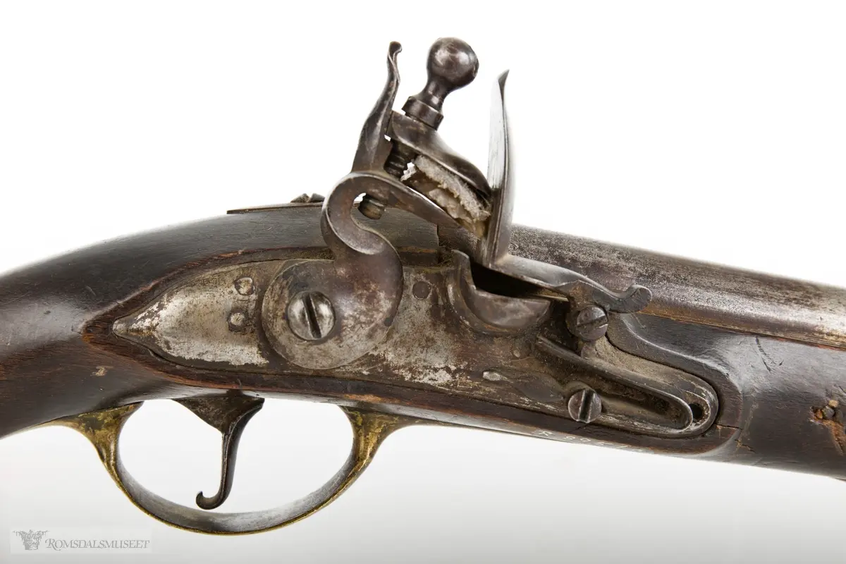 Flintlåspistol med glattboret løp, uten baksikte og med åpent korn. Skjefte av bøk med messingbeslag i enden og ved munningen. To røkner med ladestokk.