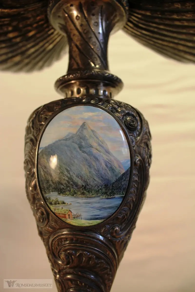 To emaljerte medaljonger: Byvåpen og Romsdalshorn.