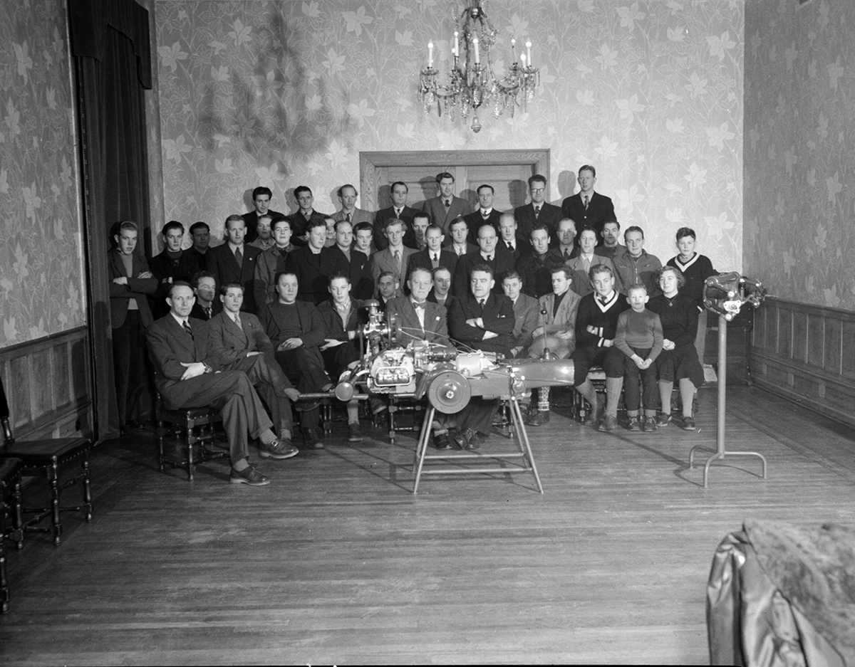 Hamar, Østregate 11 - 13, Ivar Olrud etablerte Olrud Auto i 1929, bilforhandler, bilverksted og bensinstasjon, Gruppe 40, anstatte og ledere, hele staben på kundeservicekurs. 1. rekke fra venstre nr . 9  Ivar Olrud. yngste deltakere var sønnene Ivar Wilhelm Olrud 15 år, Eivind Olrud 13 år og Jon Olrud 9 år, bilmotor i forgrunnen,