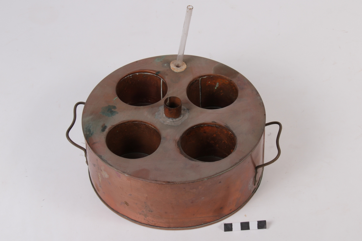 Med 4 hull til å sette flasker eller liknande. to hol til å tømma i vatn.