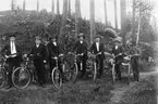Sju män med cyklar.
