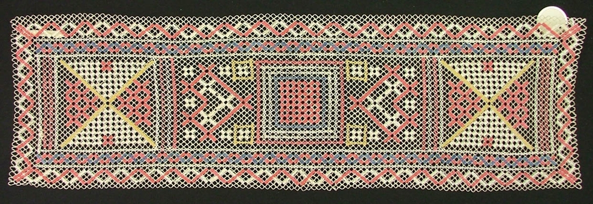 Löpare 50 x 15 cm. Sanders. Vitt nät, knutet av lingarn. Broderi i rosa, blått, gult. Trädning, ngt korssöm.