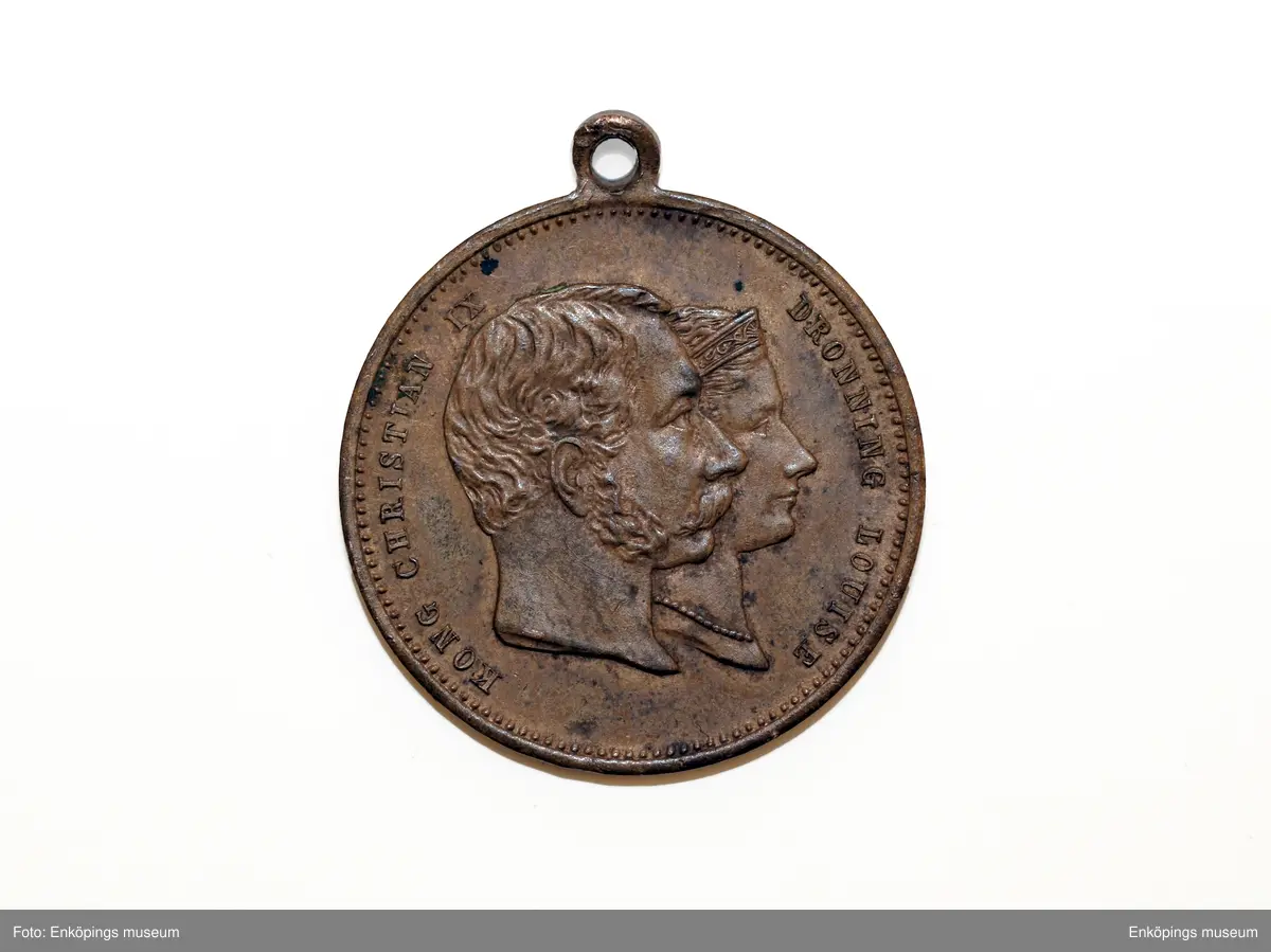 Berlockk av gulmetall utgiven i samband med det danska kungaparets guldbröllop 1892. Åtsidan avbildar Christian IX och Drottning Louise i högerprofil. Frånsidan har en inskrift: " TILL ERINDRING OM DET DANSKE KONGEPARS GULDBRYLLUP DEN 26 MAJ 1892", i överkanten har medaljen en liten ögla.