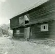 Ekonomibyggnad i korsknut. Flyttad till hembygdsgården 1953 av Karlslunda hembygdsförening.