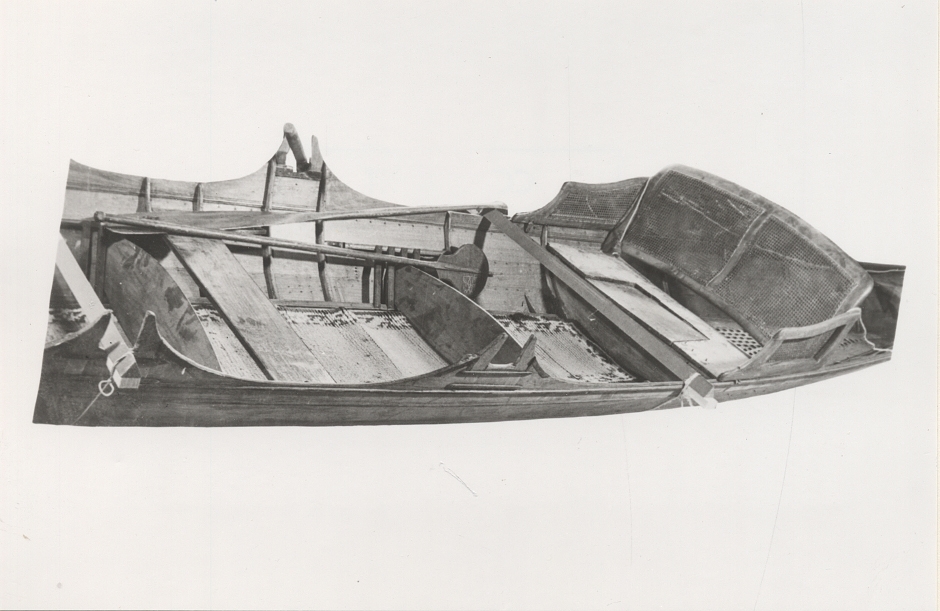 A Thames skiff is a traditional River Thames wooden rowing boat used for skiffing. These boats evolved from Thames wherries in the Victorian era to meet a passion for river exploration and leisure outings on the water. 
This boat was probably built prior to 1893. It came with a rya rug, three pairs of oars, an umbrella, two cushions, a mast and a combined boat hook and paddle. 
It was brought to Sweden by Albert Isaksson, who was the Swedish representative of Lloyd's.
The boat was later bought by Sven Abrahamsson and Börjessons boatyard on Rindö in the Stockholm archipelago. In 1931, it was sold to Ragnar Vinberg on Blidö.
