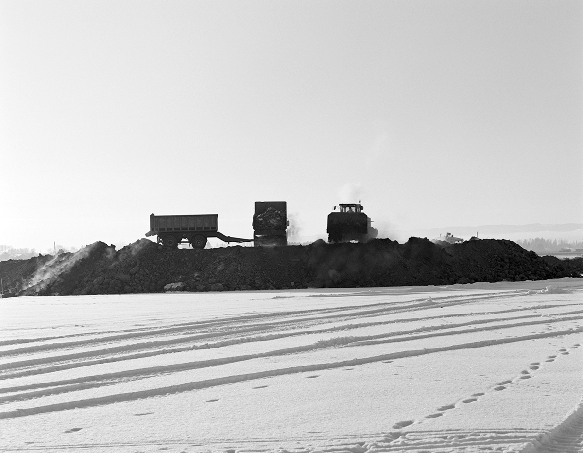 Åkersvika, Hamar. Utfylling i forbindelse med bygging av Hamar Olympiahall, Vikingskipet, oversikt, anleggsmaskiner, damp fra jordmasser, mellom 15-20 kuldegrader,vinter.