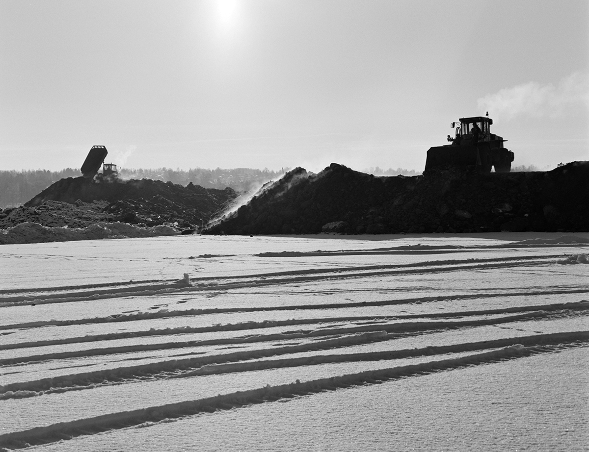 Åkersvika, Hamar. Utfylling i forbindelse med bygging av Hamar Olympiahall, Vikingskipet, oversikt, anleggsmaskiner, damp fra jordmasser, mellom 15-20 kuldegrader,vinter.