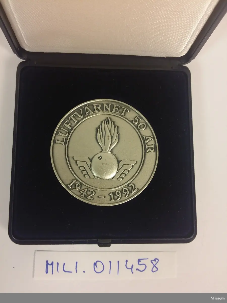 Luftvärnets jubileumsjetong i valören silver, med tillhörande etui i blå plast.