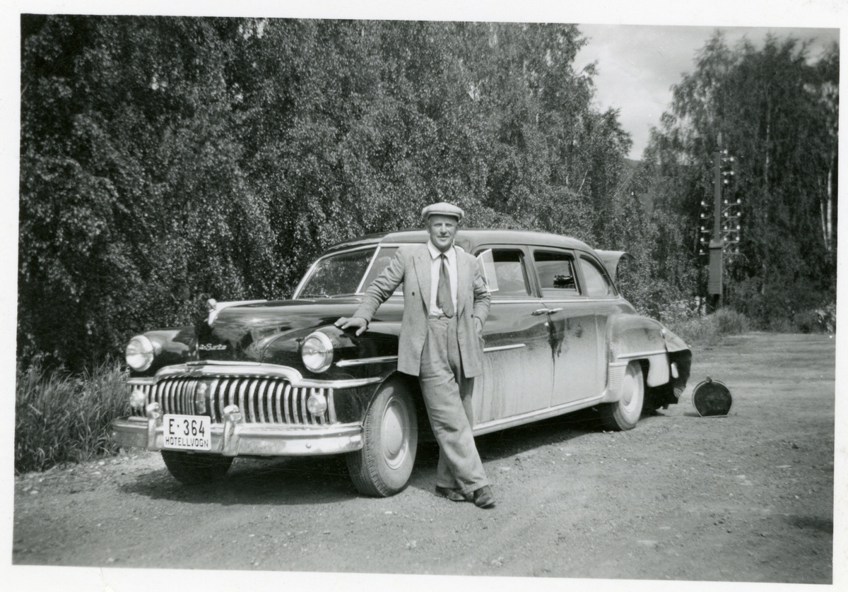 Olaf Bruhallen med hotellgjester i ihotellbilen. Merket er Desoto.
