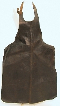 Förskinn av läder som är skuret i ett stycke. Förskinnet har tre fastsydda remmar varav en rem ska ligga runt halsen och två remmar runt midjan. Spännen på remmarna är av metall.