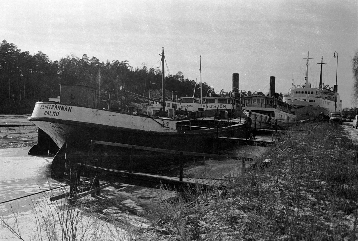 Fartyg vid Ekensbergs varv 1970. Närmast transportpråmen, f d bogserbåten FLINTRÄNNAN. I bakgrunden fr v t h DROTTNINGHOLM (urspr. VALKYRIAN), MÄLARDROTT (urspr. GRISSLAN), SALTSJÖN (1925) och ÖSTANÅ I (1906). Längst bak ses Gotlandsfärjan POLHEM (urspr. KRAAKERØ).
