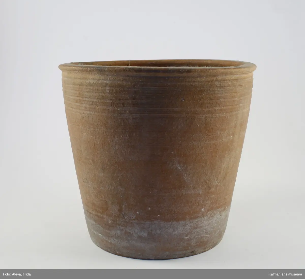 KLM 34927. Blomkruka, av lergods. Chamotterad gulröd skärv. Drejfåror.