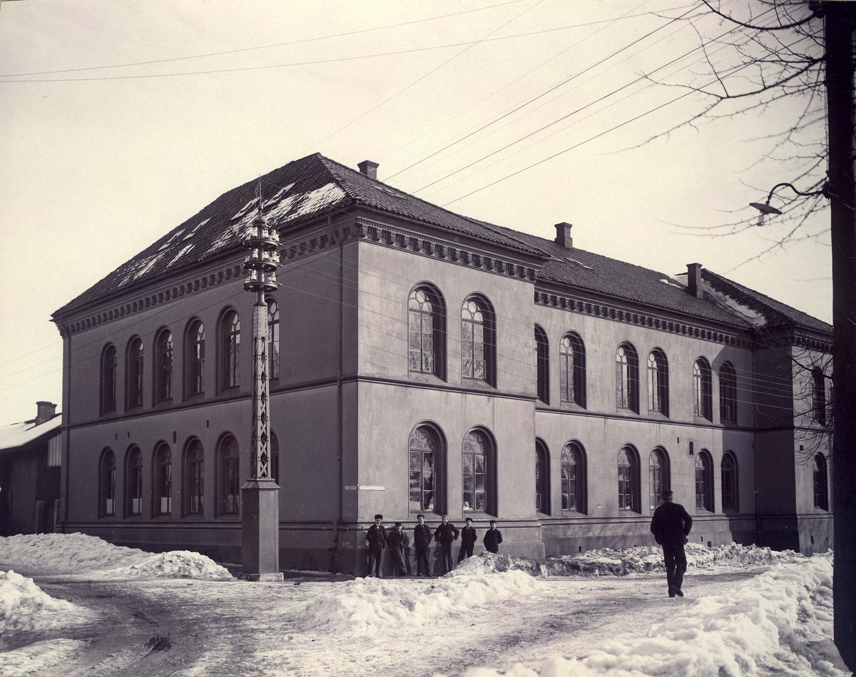 Fredrikstad. Vestsiden. Krysset Skolegaten/Ferjestedsveien. ad høiere Almenskole. Sklen påbygget en etasje i 1898. Snøvinter.