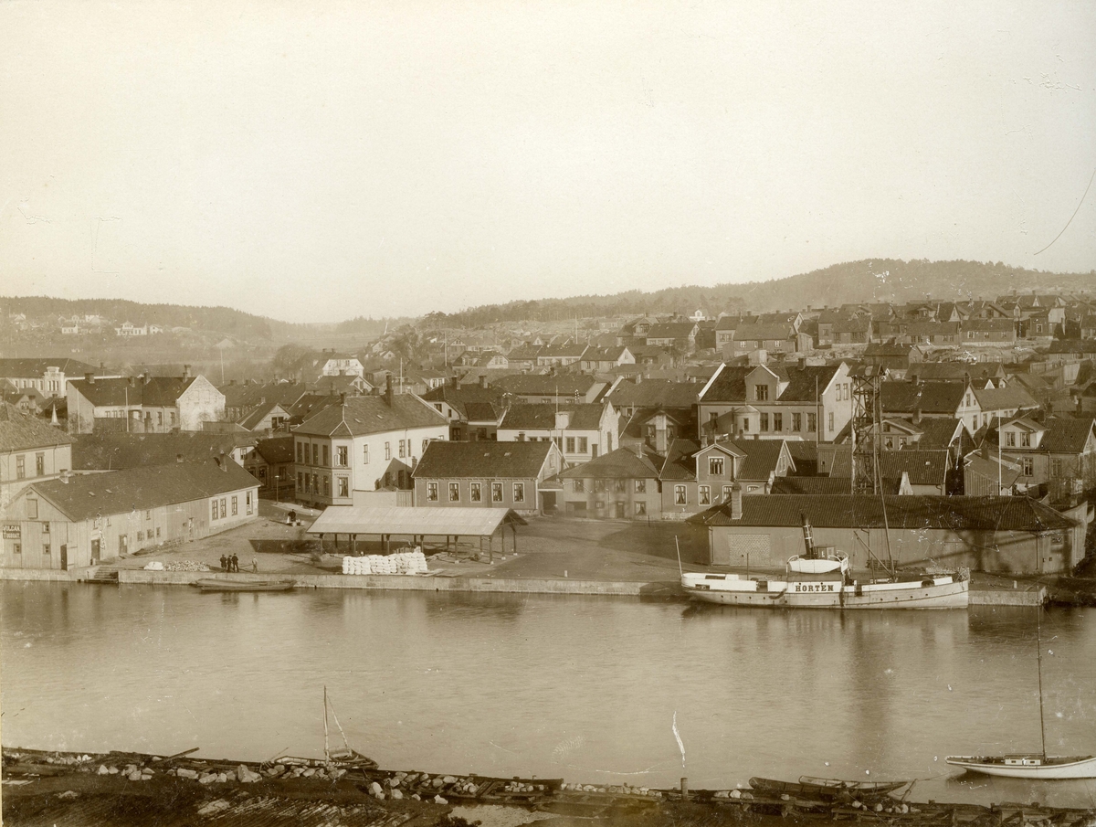 Fredrikstad. Vestsiden. Dampskisbrygga. Dampskipsbrygga 10-8-6-4 (bygningene vendt mot torvet fra venstre mot høyre). Nr 10 (fra venstre) Vestsiden Apotek / Fredriksstad Spareskillingsbank / Fredrikstad og omegn Boligbyggelag (i 1984). - Nr 8 Seilmaker Th. Andresen. Fredrikstad Brannstasjon (Den lange bygningen bak D/S Hvaler) til høyre på bildet. Dampskipsbrygga 6: Her bygget Carl Nordby en stor murbygning. Nordby drev gjennom mange år sin damskipsekspedisjon her, samt befraktning og klarering, spedisjontransport og assuranse.  Det var et stort og anerkjent firma. Sønnene Knut og Gunnar overtok  etter farens bortgang. - Ved kai: D/S Horten. - Storgaten 1 (lange bygningen i venstre billedkant). Søren Selenius paraplymaker / pipe- og  sigarforretning drev virksomhet i bygningen.
Glomma - Vesterelven. D/S Horten ligger til kai.  - Husene i bakgrunnen ligger på Apenesfjellet. 
Arbeiderforeningen i bakgrunnen i venstre billedkant. - Bildet er tatt fra Kråkeøy. Foto: Carl Sandels.