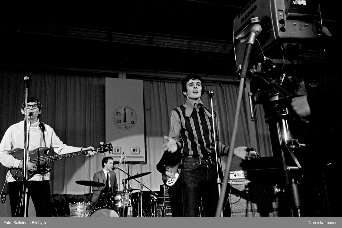 Den brittiska popgruppen The Zombies uppträder på TV-programmet Drop-In 1966. Framför scenen en tv-kamera.