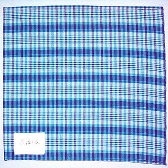 Rutigt vävprov i bomullsgarn vävt i tuskaft. Varp i tre nyanser blått och blågrönt, inslag i tre nyanser blått, blågrönt och oblekt. Provet har en påsydd tygetikett med texten: "T. 1286.".Tygprovet är ihopfäst med ytterligare tjugoåtta prover (inv.nr 77 - 80, 82 - 100) med snören.