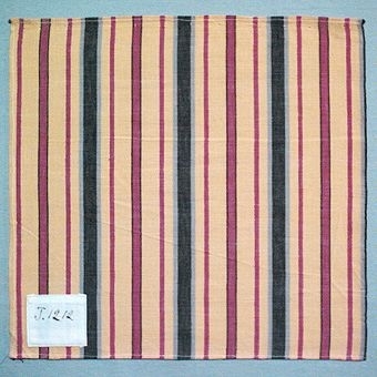 Randigt vävprov i bomull, vävt i tuskaft. Varp i gult, svart, brunt och grått, inslag i naturvitt. Märkt med påsydd tyglapp med texten: "T. 1212". Vävprovet sitter ihopfästat med snören, med ytterligare tjugoåtta vävprover ( inv.nr 77 - 91, 93 - 100).