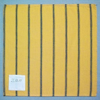 Randigt vävprov i bomull, vävt i tuskaft. Varp i gult, blått och svart, brunt, inslag i gult. Märkt med påsydd tyglapp med texten: "T. 1210". Vävprovet sitter ihopfästat med snören, med ytterligare tjugoåtta vävprover ( inv.nr 77 - 92, 94 - 100).