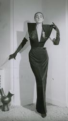 Mannekäng i v-ringad aftonklänning med stärkt axelparti och 